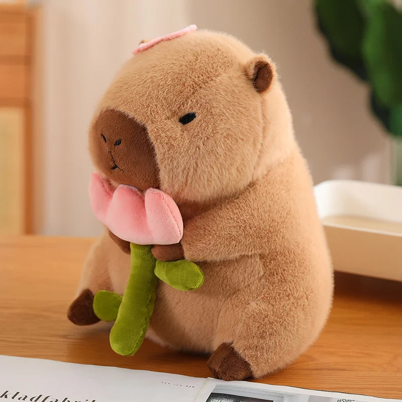 Capybara plush holding a pink flower — a super soft cuddly toy that makes one of the most charming nice secret santa gifts for any age.