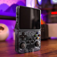 Black retro game handheld beside monitor, travel gaming console design