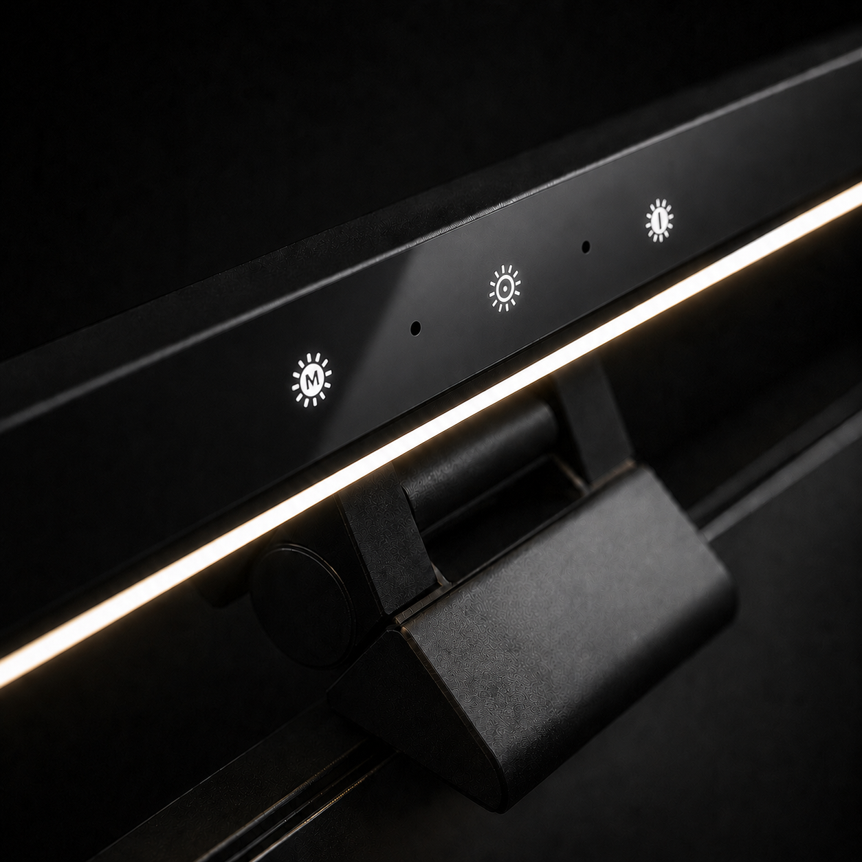 Close-up of an RGB monitor light bar showing the front controls, illuminated task light and gravity-weighted monitor clamp