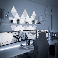 RGB triangle LED wall panels illuminating a gaming desk with vibrant colour lighting
