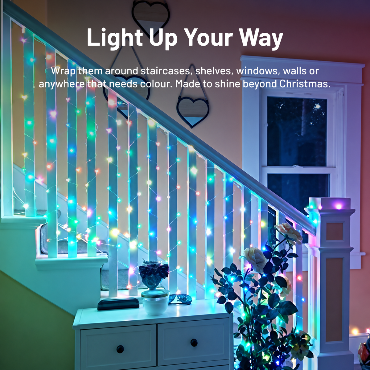 Smart colour-changing fairy lights wrapped around an indoor staircase