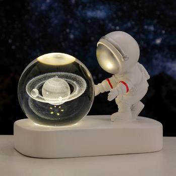 Astronaut holding galaxy globe lamp glowing with warm white ambient lighting