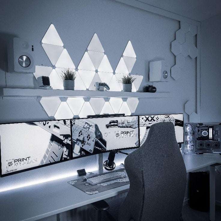 RGB triangle LED wall panels illuminating a gaming desk with vibrant colour lighting