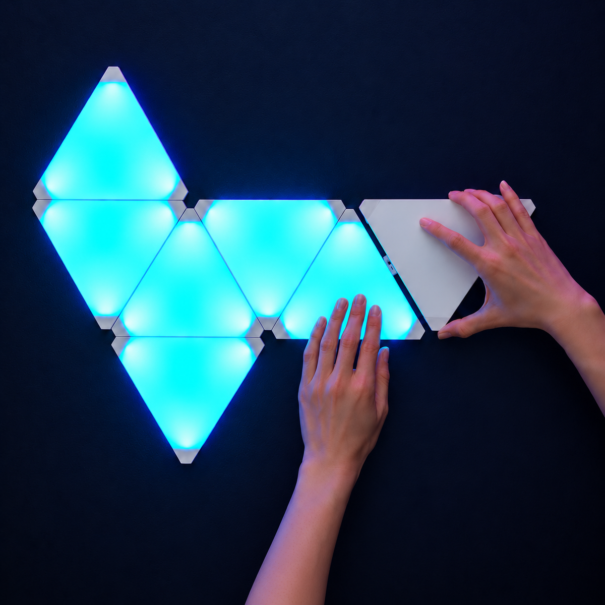 Triangle LED panels being mounted onto a wall as part of a modular lighting layout
