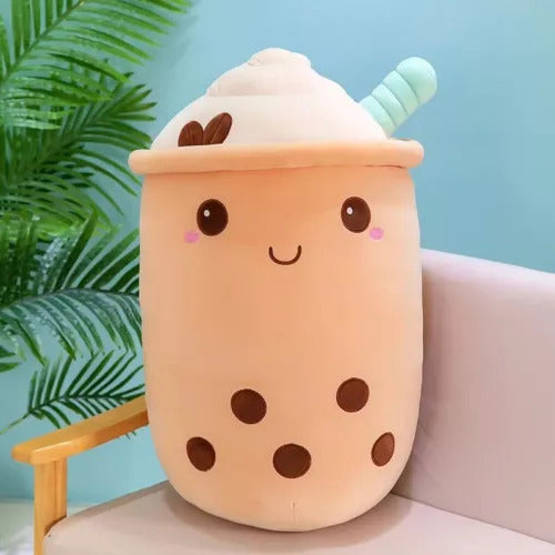 Brown boba tea plush toy with whipped cream top on wooden surface, cozy home décor accent